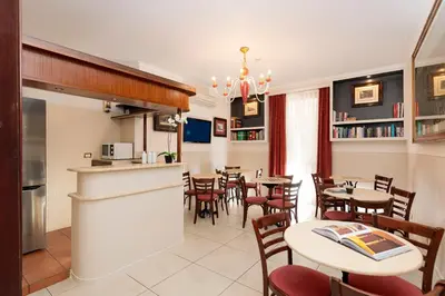 a restaurant with tables and chairs and a kitchen at Budget Rooms Des Arts in Rome