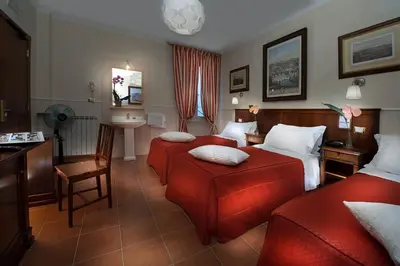 a hotel room with two beds and a desk at Budget Rooms Des Arts in Rome