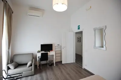 a living room with a chair and a desk with a computer at Le Fontane di Roma in Rome
