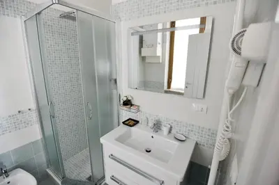 a white bathroom with a sink and a shower at Le Fontane di Roma in Rome
