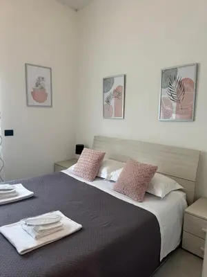 a bedroom with a large bed with two pink pillows at Flaminio Holidays in Rome