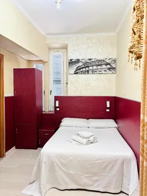 a bedroom with a white bed with a red headboard at Vertex Palace in Rome