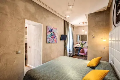 a bedroom with a bed with yellow pillows at Parlamento Boutique Hotel in Rome
