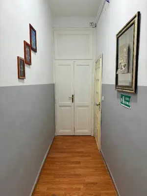 a hallway with a white door and paintings on the wall at Vertex Suite in Rome