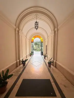 an empty hallway with a large archway with potted plants at Vertex Suite in Rome