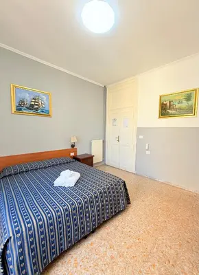 a bedroom with a bed with a blue and white blanket at Vertex Suite in Rome