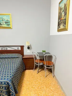 a bedroom with a bed and a table and chairs at Vertex Suite in Rome