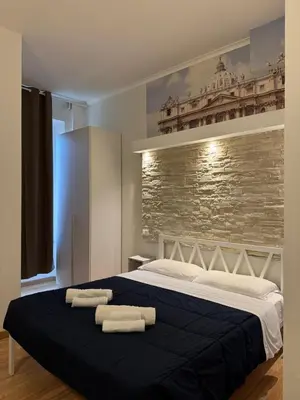a bedroom with a large bed with two towels on it at Rooma Beb in Rome