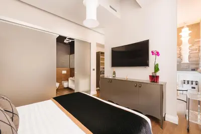 a bedroom with a bed and a tv on a wall at DC Collection Spagna in Rome