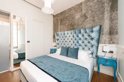 a bedroom with a bed with a blue headboard at DC Collection Spagna in Rome