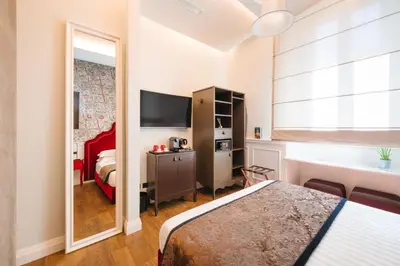 a hotel room with two beds and a mirror at DC Collection Spagna in Rome