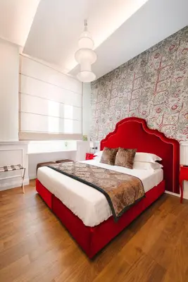 a bedroom with a large bed with a red headboard at DC Collection Spagna in Rome