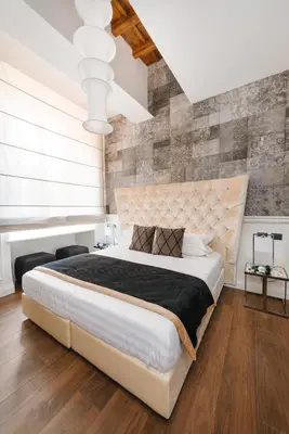 a bedroom with a large white bed and a brick wall at DC Collection Spagna in Rome