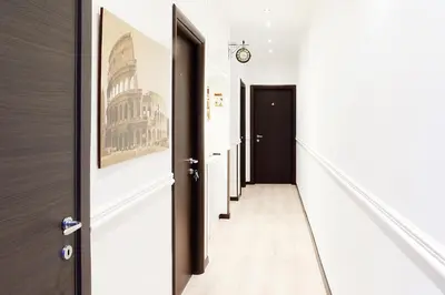a hallway with black doors and white walls at Roman Residence in Rome