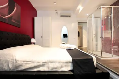 a bedroom with a large bed and a red wall at Rome Services Borgo Suites in Rome