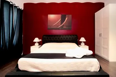 a bedroom with a bed with a red wall at Rome Services Borgo Suites in Rome