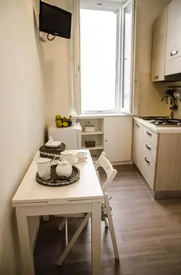 a small kitchen with a white table and a window at Madonna dei Monti in Rome