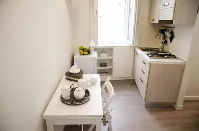 a small white kitchen with a table and chairs at Madonna dei Monti in Rome