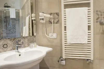 a bathroom with a sink and a mirror and towels at Leonardo Da Vinci Guest House in Rome