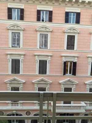 a pink building with many windows in front of it at Our Home in Rome - Via Machiavelli in Rome