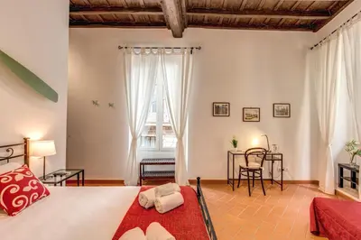 a bedroom with a bed and a table and chairs at Piccolo Trevi Suites in Rome