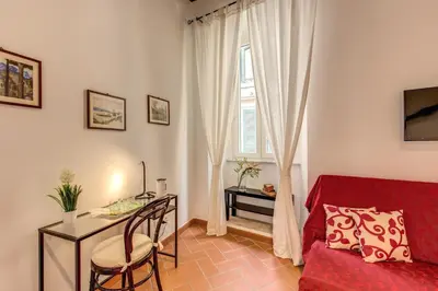 a living room with a desk and a red couch at Piccolo Trevi Suites in Rome