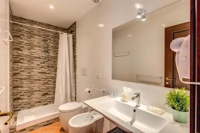a bathroom with a sink and a toilet and a mirror at Piccolo Trevi Suites in Rome
