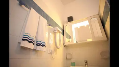 a bathroom with a sink and a mirror and towels at Residenza Matilde in Rome