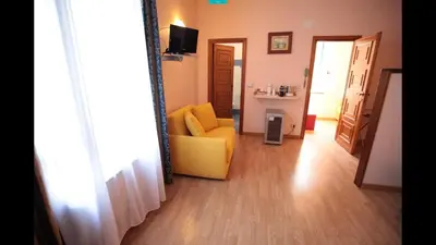 a living room with a yellow chair and a sink at Residenza Matilde in Rome
