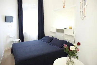 a bedroom with a blue bed and a vase with flowers at B&B Roma Olimpic in Rome