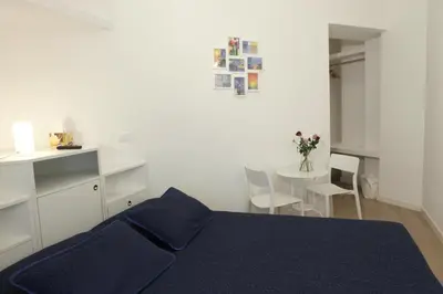 a living room with a blue couch and a chair at B&B Roma Olimpic in Rome
