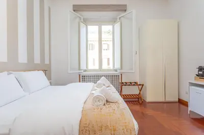 a bedroom with a white bed and a window at Easybnb - Dea Roma in Rome
