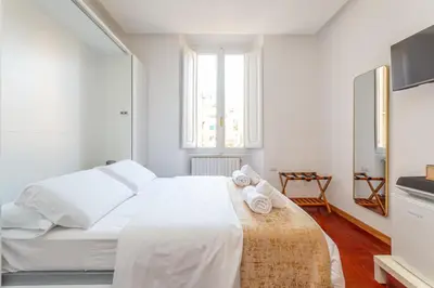 a white bedroom with a bed with towels on it at Easybnb - Dea Roma in Rome