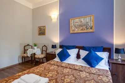 a bedroom with a large bed with blue walls at Raphael Rooms in Rome