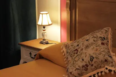 a lamp sitting on a table next to a bed at Raphael Rooms in Rome