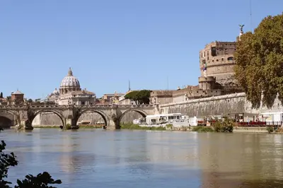 a bridge over a river with buildings in the background at Raphael Rooms in Rome