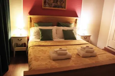 a bedroom with a large bed with two towels on it at Raphael Rooms in Rome