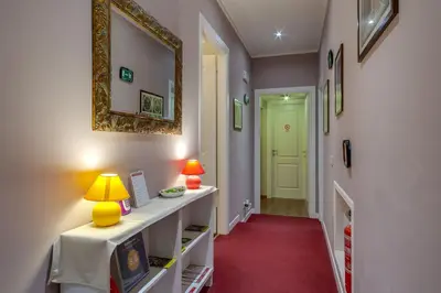a hallway with a red carpet and a yellow mirror at Raphael Rooms in Rome