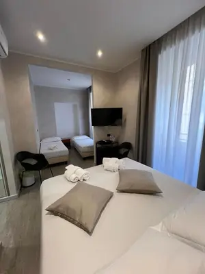 a bedroom with a large white bed with towels on it at Hotel Ercoli House in Rome