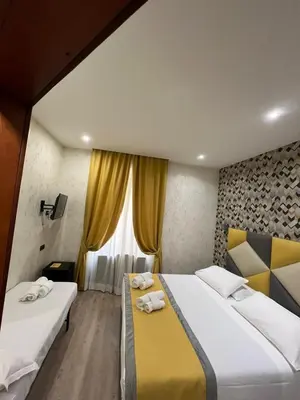 a hotel room with two beds and a window at Hotel Ercoli House in Rome