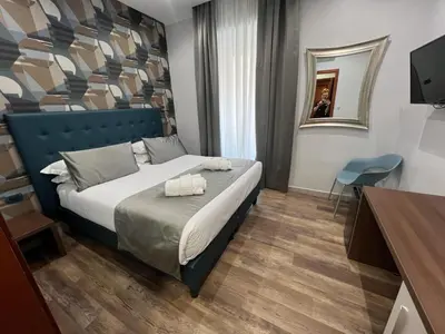 a bedroom with a bed with two towels on it at Hotel Ercoli House in Rome