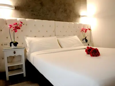 a bedroom with a white bed with red flowers on it at Easyrome Guest House in Rome