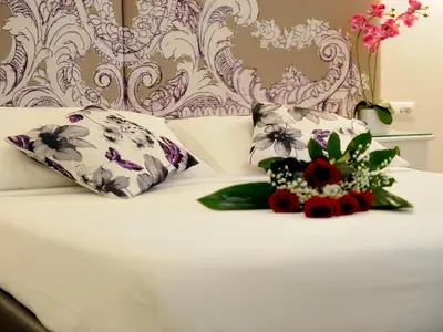a bed with two pillows and flowers on it at Easyrome Guest House in Rome