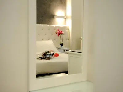 a bedroom with a white bed with a mirror at Easyrome Guest House in Rome