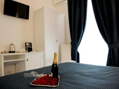 a bottle of champagne and a tray of red hearts on a table at Easyrome Guest House in Rome