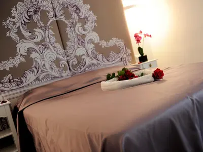 a white bed with two red roses on it at Easyrome Guest House in Rome
