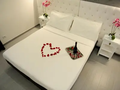 a white bed with a bottle of wine and a tray on it at Easyrome Guest House in Rome