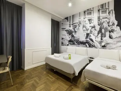 a room with two beds and a painting on the wall at B&B Hotel Roma Italia Viminale in Rome