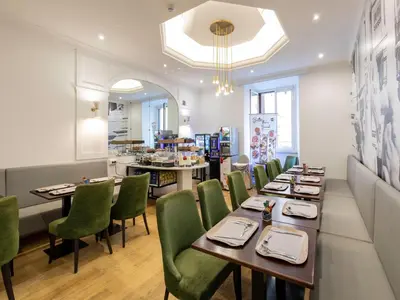 a restaurant with wooden tables and green chairs at B&B Hotel Roma Italia Viminale in Rome