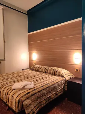a bedroom with a bed with a wooden headboard at Hotel Milazzo Roma in Rome